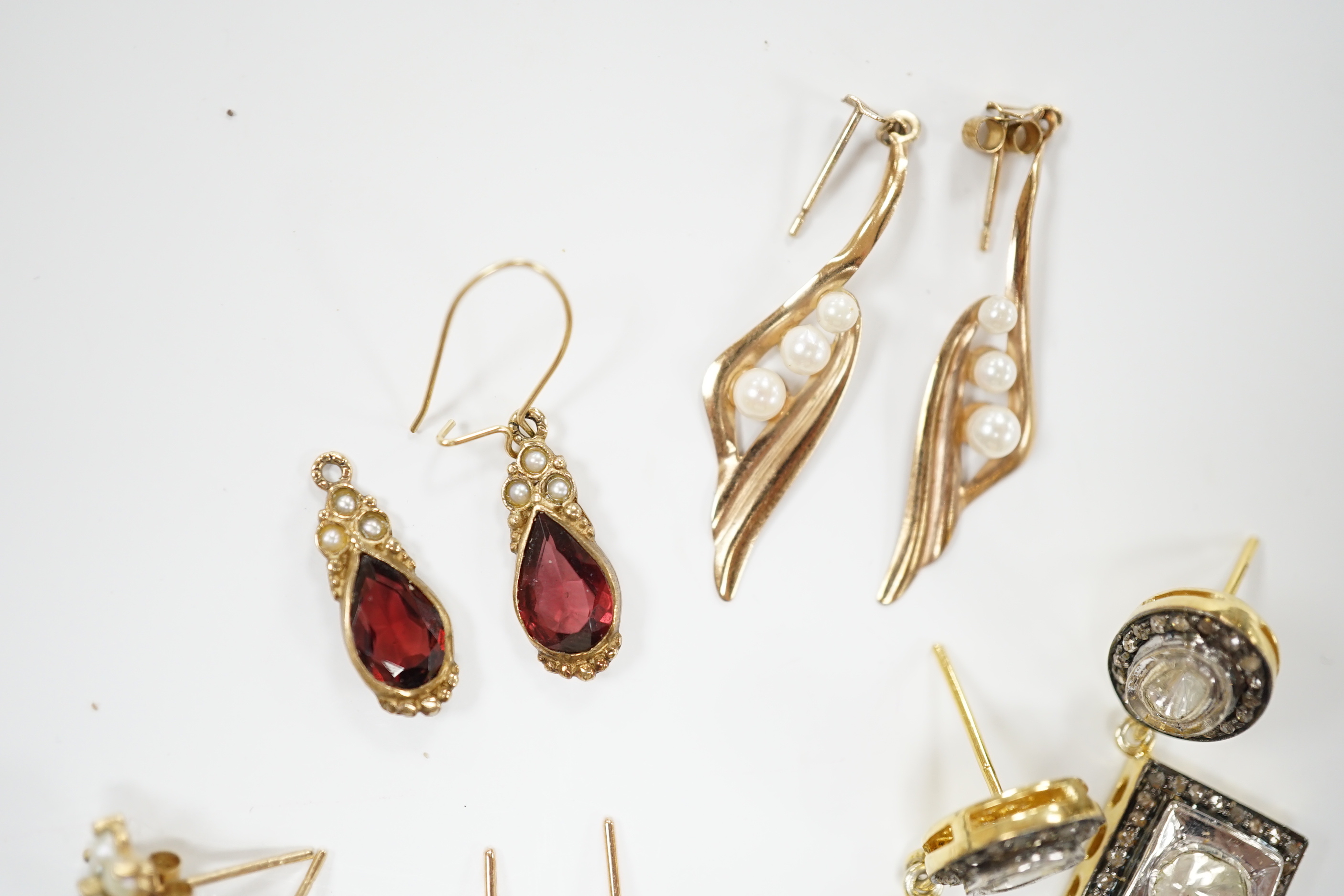 A modern pair of 9ct and garnet? earrings, a pair of Indian? yellow metal and diamond cluster set drop earrings and three other pairs of yellow metal earrings including single stone cultured pearl.